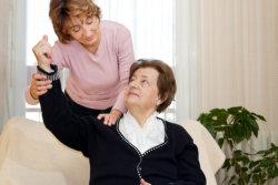 caretaker assisting her patient in exercise